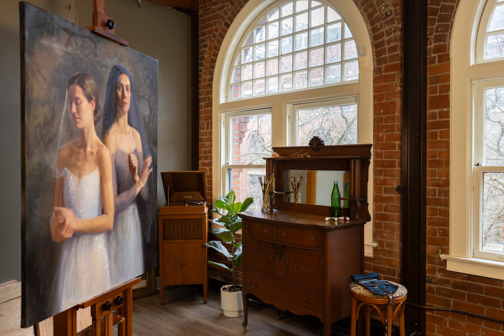 A large painting of two women in white dresses beside an arched window